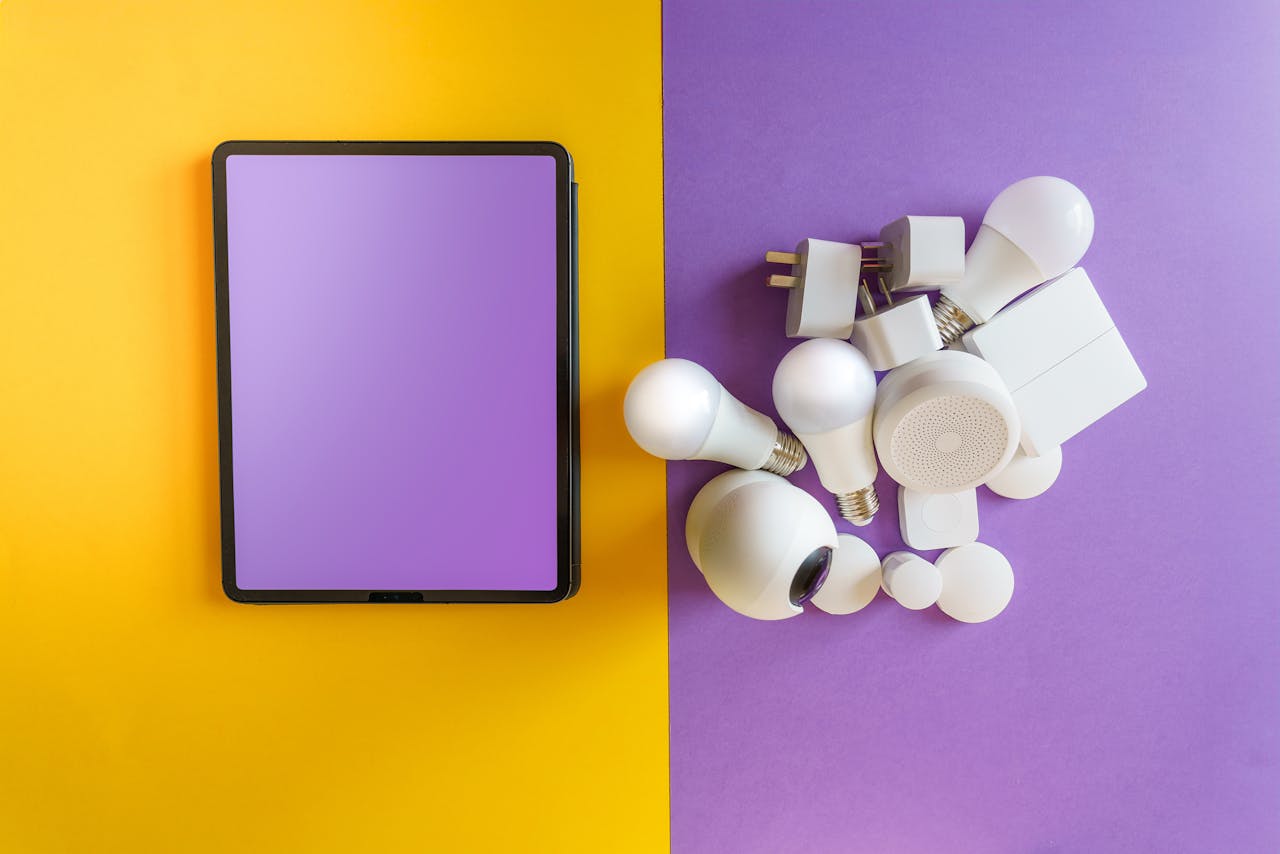 why-choose-us A collection of smart home devices beside a blank tablet on yellow and purple background.