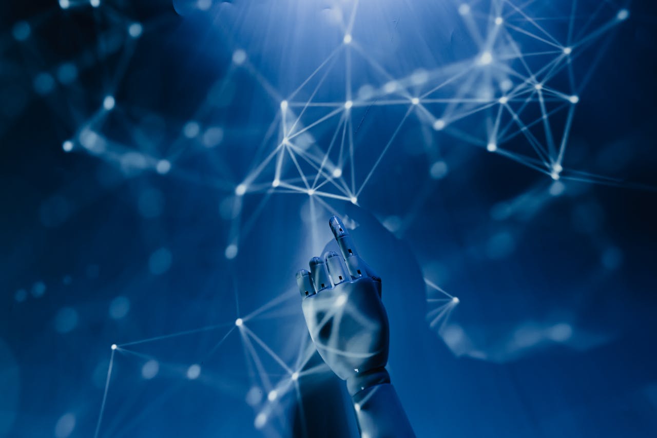 gallery-3 A robotic hand reaching into a digital network on a blue background, symbolizing AI technology.